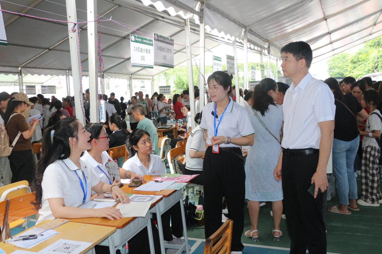 3.学校副校长黄强新（右一）在现场详细了解各专业新生报到情况